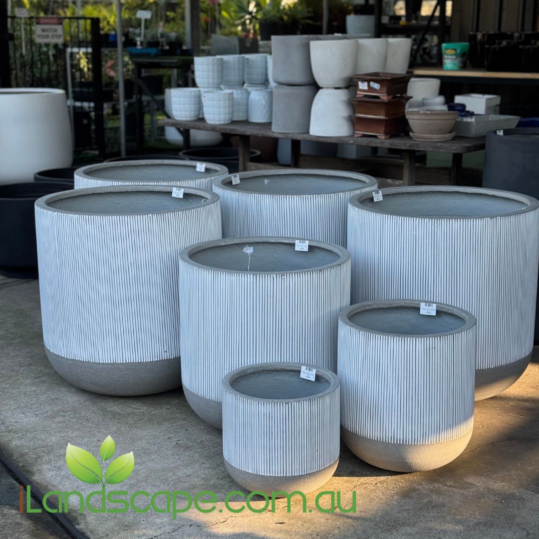 Set of gray cylindrical planters with ribbed texture on a concrete surface, brand 'Landscape.com.au' visible.