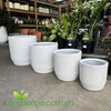 White textured planters on a concrete floor with plants and pots in the background, featuring the iLandscape.com.au logo.