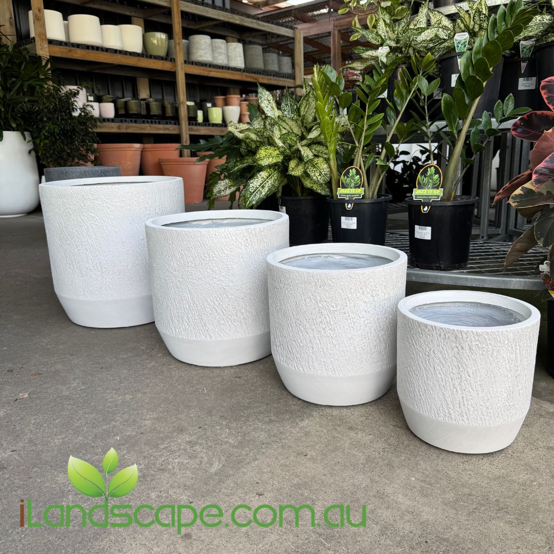 White textured planters on a concrete floor with plants and pots in the background, featuring the iLandscape.com.au logo.