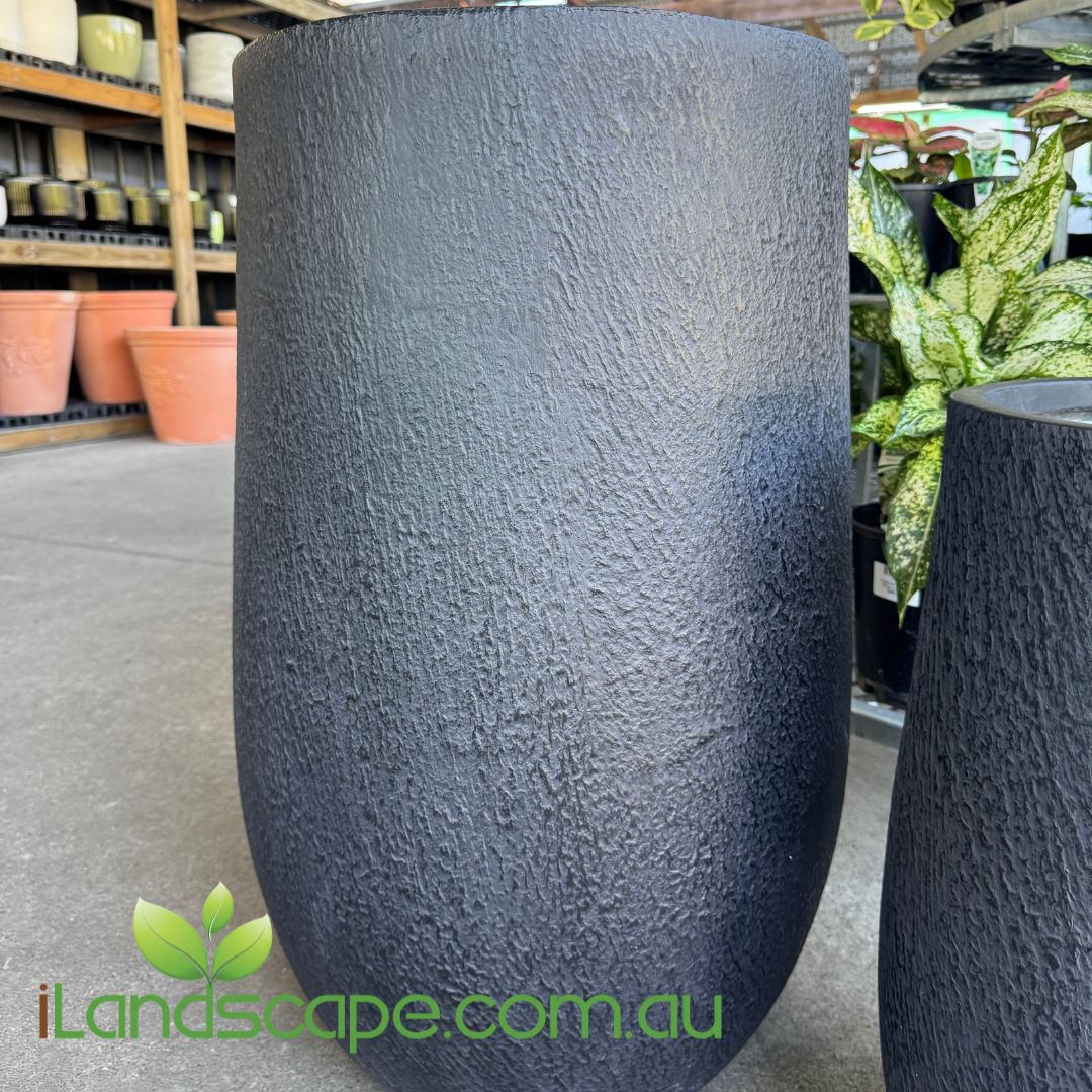 Textured black pot in a garden center setting with 'iLandscape.com.au' branding.